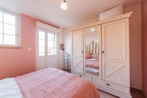 a bedroom with a bed and a large white cabinet at Appartement privé Le Chardonnay, jardin, parking in Buchères