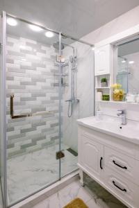 een witte badkamer met een douche en een wastafel bij hotelise I Mermaid Apartment in Jerevan