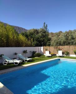 a swimming pool with blue water in a yard at CORTIJO LALO in Órgiva