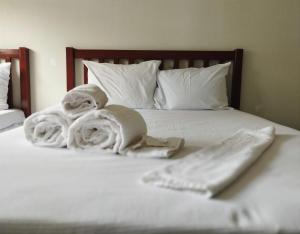 un letto con asciugamani e cuscini sopra di Novohotel Express a Santana do Livramento