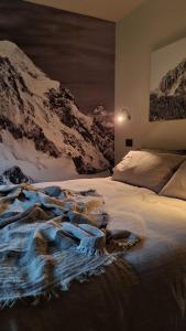 een slaapkamer met een bed en met sneeuw bedekte bergen bij Cocooning in Arvier