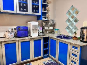 eine Küche mit blauen Schränken und einem Waschbecken in der Unterkunft Iman Homestay: Sri Kandis in Kuching