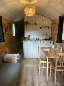 a kitchen and dining room with a table and a couch at La Roulotte des Bois 