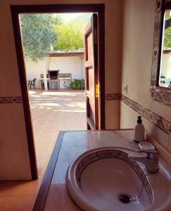 a bathroom with a sink and an open door at CORTIJO LALO in Órgiva