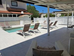 a patio with lounge chairs and a swimming pool at Il Piccolo Principe Relais in Villapiana