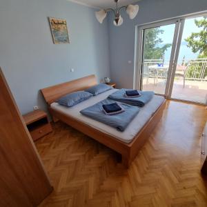 a bedroom with a bed with blue pillows on it at Villa Margarita in Selce