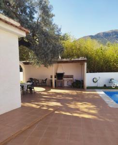 un patio con mesa y una cocina junto a una casa en CORTIJO LALO, en Órgiva