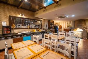 a restaurant with wooden tables and white chairs and a counter at YIT Puerta Bisagra in Toledo