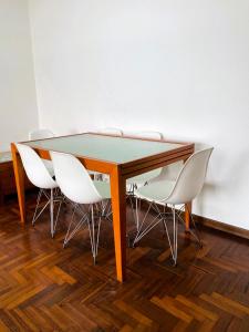a table with white chairs around it in a room at Apartamento Playa Calzoa in Vigo
