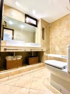 a bathroom with a toilet and a sink and a mirror at Apartamento Playa Calzoa in Vigo