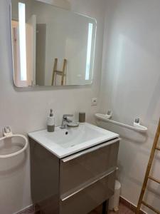 a bathroom with a sink and a toilet and a mirror at 2 Pièces Piscine Parking Clim - Le Fairway in Mandelieu-La Napoule