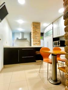 a kitchen with orange chairs and a table in a room at Apartamento Playa Calzoa in Vigo