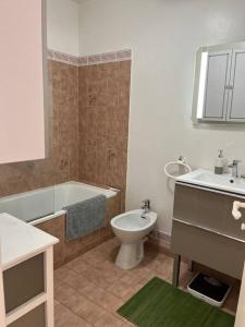 een badkamer met een bad, een toilet en een wastafel bij 2 Pièces Piscine Parking Clim - Le Fairway in Mandelieu-la-Napoule