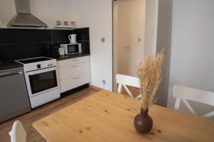 a kitchen with a wooden table with a vase on it at Le Luma in Colmar +11 photos