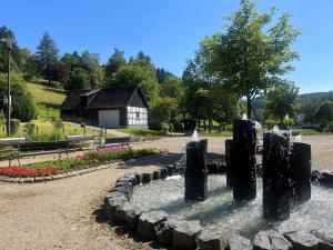 a fountain in the middle of a park with a barn at Haus Schmitten in Winterberg