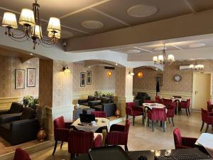 un ristorante con divani, tavoli e sedie di Edisem Hotel a Tirana