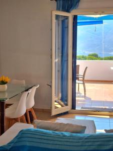 a room with a dining table and a view of a patio at Zafeiris Apartments in Livadia