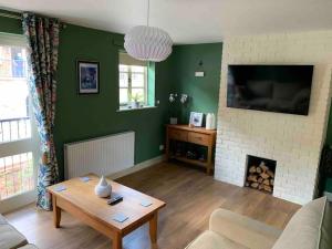 a living room with a table and a fireplace at Salthouse Cottage in Ironbridge in Telford