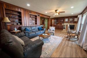 a living room with a leather couch and a table at Beautiful home on Lake Michigan, near Escanaba 