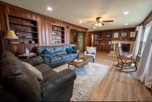 a living room with a leather couch and a table at Beautiful home on Lake Michigan, near Escanaba in Bark River