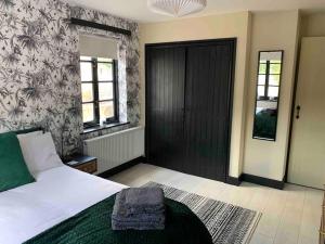 a bedroom with a bed and a black door at Salthouse Cottage in Ironbridge in Telford