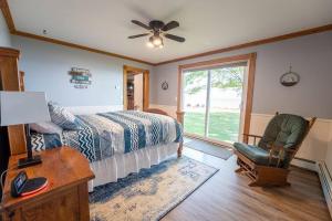 a bedroom with a bed and a chair and a window at Beautiful home on Lake Michigan, near Escanaba 