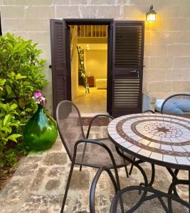 un patio con 2 sillas y una mesa con un jarrón en L'antico Trullo - Masseria Chiancarella, en Fasano