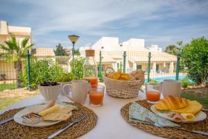 uma mesa com alimentos e bebidas ao pequeno-almoço numa varanda em Glenridge Resort By Albufeira Rental em Albufeira