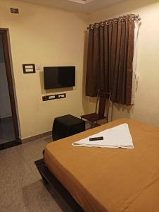 Habitación de hotel con cama y TV de pantalla plana. en ANTARA STAY, en Coimbatore