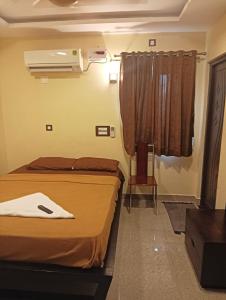 Habitación de hotel con 2 camas y ventana en ANTARA STAY, en Coimbatore