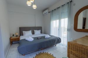 een slaapkamer met een bed met twee handdoeken erop bij Marele Hills Boutique Apartments in Nea Fokea