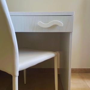 un escritorio con una silla blanca junto a una mesa en NuMaChi Rooms, en San Nicolò