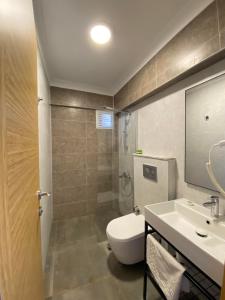 a bathroom with a toilet and a sink and a shower at Gülhan City Otel in Datca
