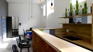 a kitchen with a counter with chairs and a sink at AppleGarden in Debrecen