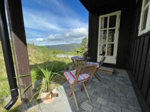 une terrasse avec une table et des chaises dans une maison dans l'établissement Gausta Lodge med 6 sengeplasser i nærhet til Gaustatoppen, à Gaustablikk