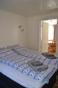 a large bed with blue and white sheets on it at Skarmyra Apartment in Moss