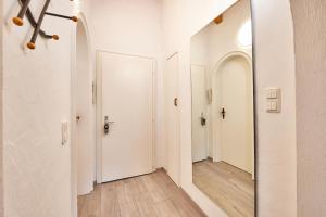 a hallway with two white doors and a mirror at Haus Alpklang in Garmisch-Partenkirchen +36 photos