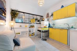 Una cocina con gabinetes amarillos y un sofá en una habitación. en Las Canteras Verol with Garage, en Las Palmas de Gran Canaria 20 fotos más