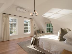 1 dormitorio con 1 cama grande y 2 ventanas en Mount Vernon Manor, en Klapmuts