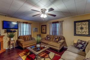a living room with two couches and a ceiling fan at Keepin' it Reel in Avinger
