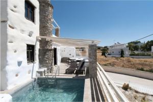 een huis met een zwembad naast een gebouw bij Villa Aspro Paros 1 in Drios