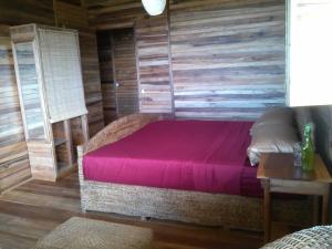 a bedroom with a bed with a wooden wall at Tierra Madre Eco Lodge in Los Andes