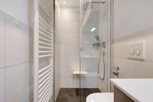 a white bathroom with a shower and a toilet at Apt Theo Val di Sogno Garda Lake in Malcesine