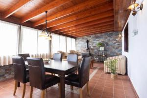 Casa Carolina في Puntillo del Sol: غرفة طعام ذات سقف خشبي وطاولة وكراسي