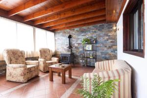 ein Wohnzimmer mit Stühlen und einem Holzofen in der Unterkunft Casa Carolina in Puntillo del Sol