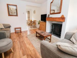 een woonkamer met een bank en een open haard bij Bluebell Cottage in Ormskirk