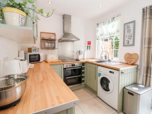 een keuken met een wasmachine en droger bij Bluebell Cottage in Ormskirk