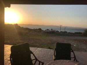 - deux chaises assises sur une terrasse offrant une vue sur le coucher du soleil dans l'établissement Moudros Sunset, à Moúdhros