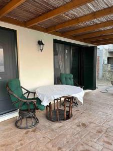 a patio with a table and chairs on a porch at Moudros Sunset in Moúdhros