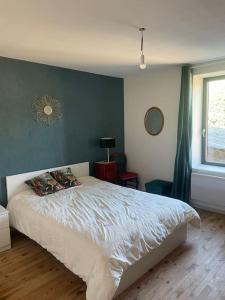 - une chambre dotée d'un lit avec un mur bleu dans l'établissement Gîte au calme dans le Parc du Livradois-Forez, à Saint-Julien-de-Coppel